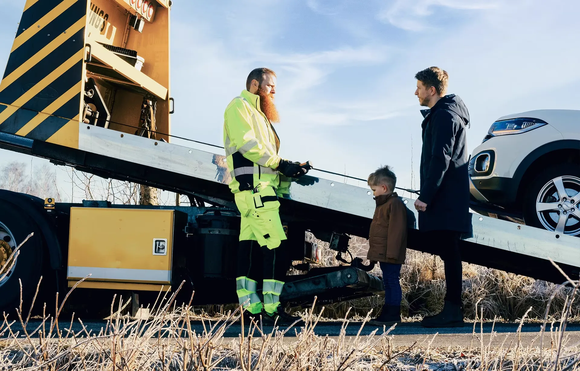 Bärgningsbil lastar en bil vid vägkanten